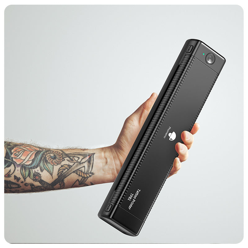 Tattooed hand holding TP81 tattoo printer in vertical position for portability